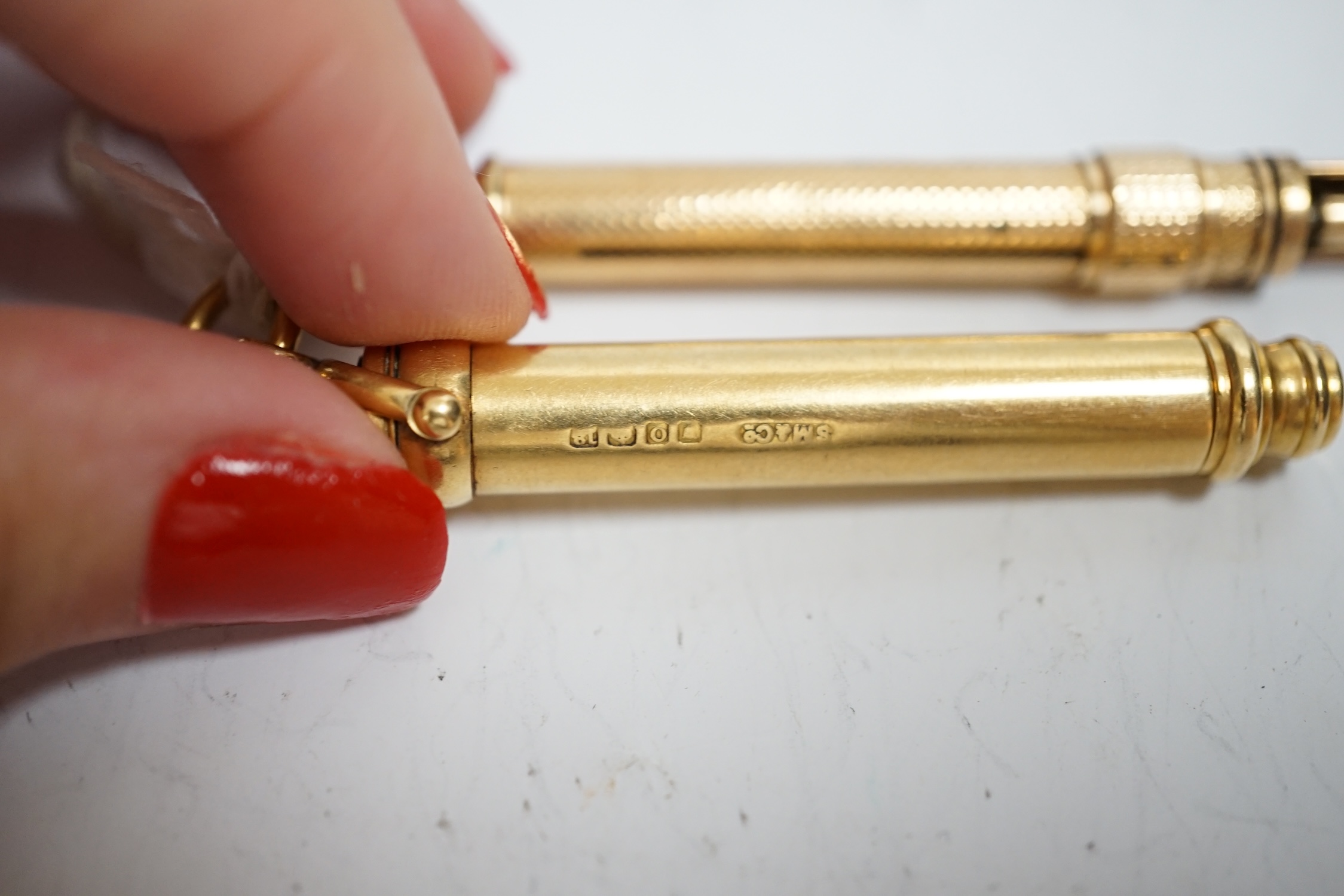 An Edwardian 18ct gold cased propelling pencil, with bloodstone set terminal, by Sampson Mordan & Co, London, 1909, closed 53mm, together with a later engine turned yellow metal propelling pencil.